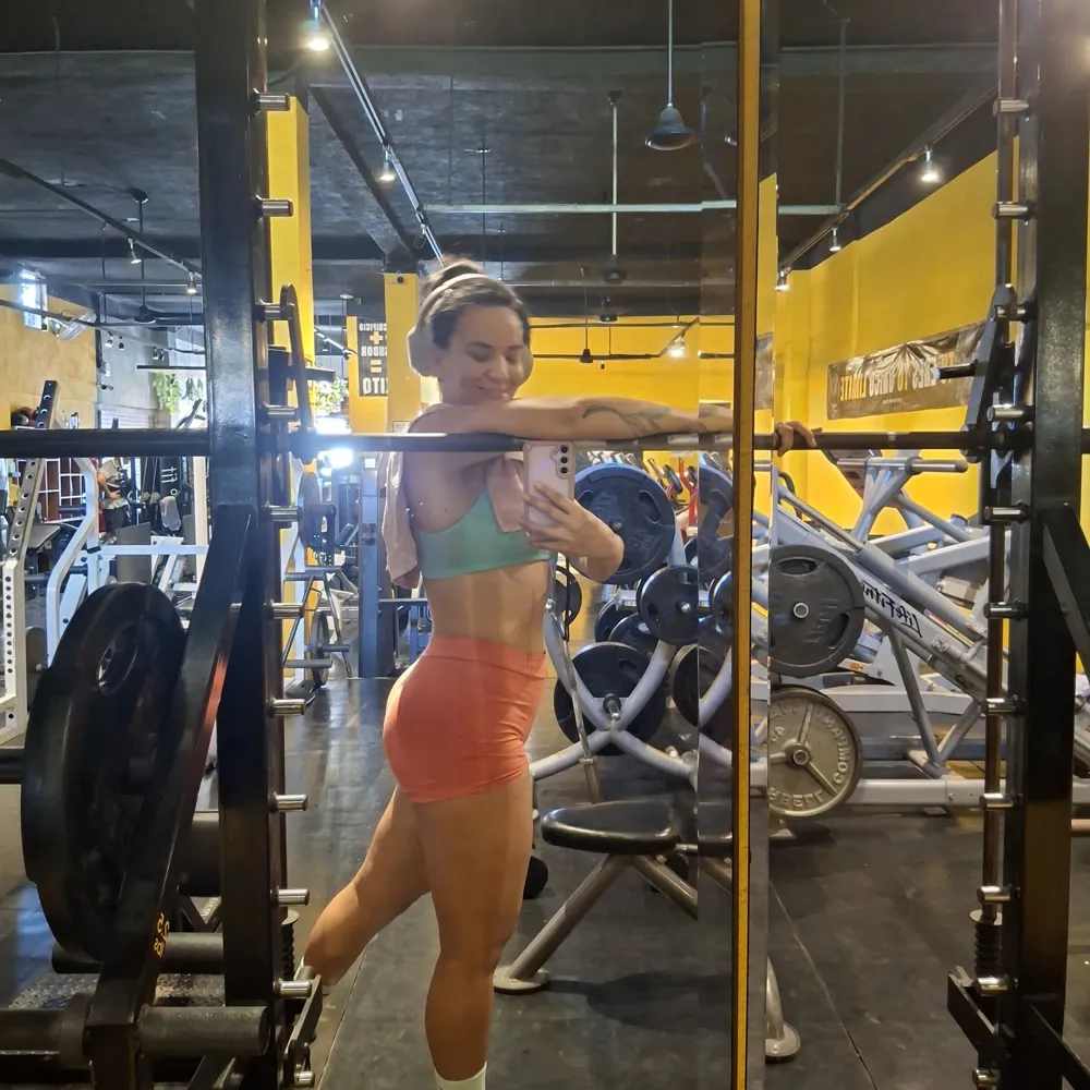 Gal Dorado leaning on the bar of the smith machine between sets