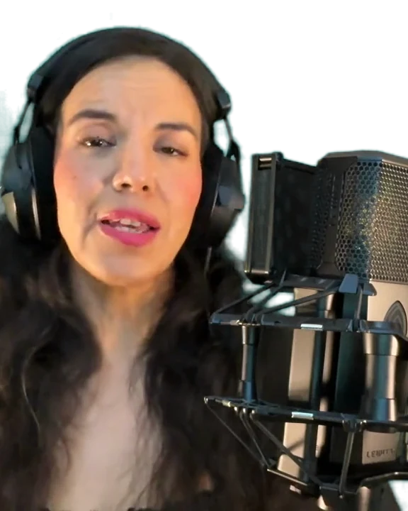Gal Dorado at a studio microphone, headphones on, mid-take